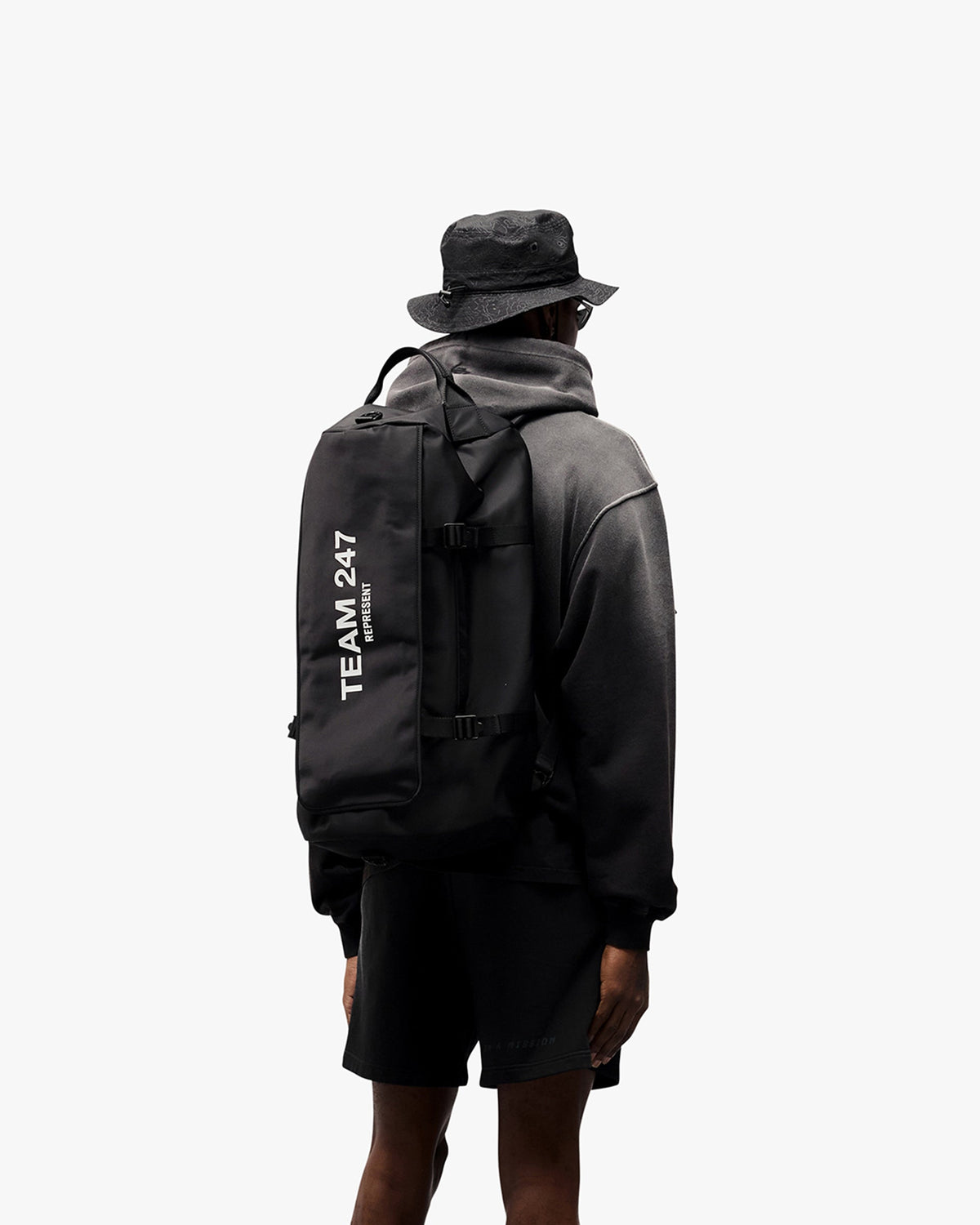 Man wearing an oversized black hoodie on a plain white background | 247 Motion Oversized Hoodie in Black | Hoodie with ribbed hems and cuffs | 247 Hoodies | Represent Clo