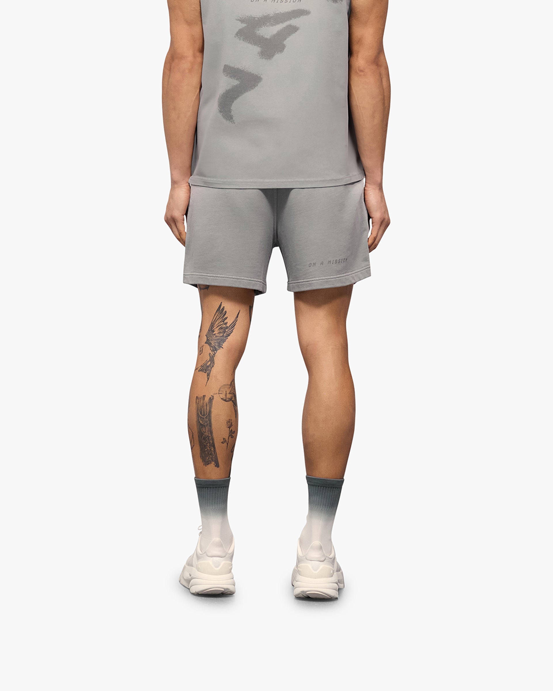 Man wearing grey shorts on a plain white background | 247 Motion Shorts in Titanium | Jersey shorts with elasticated waistband | 247 Shorts | Represent Clo