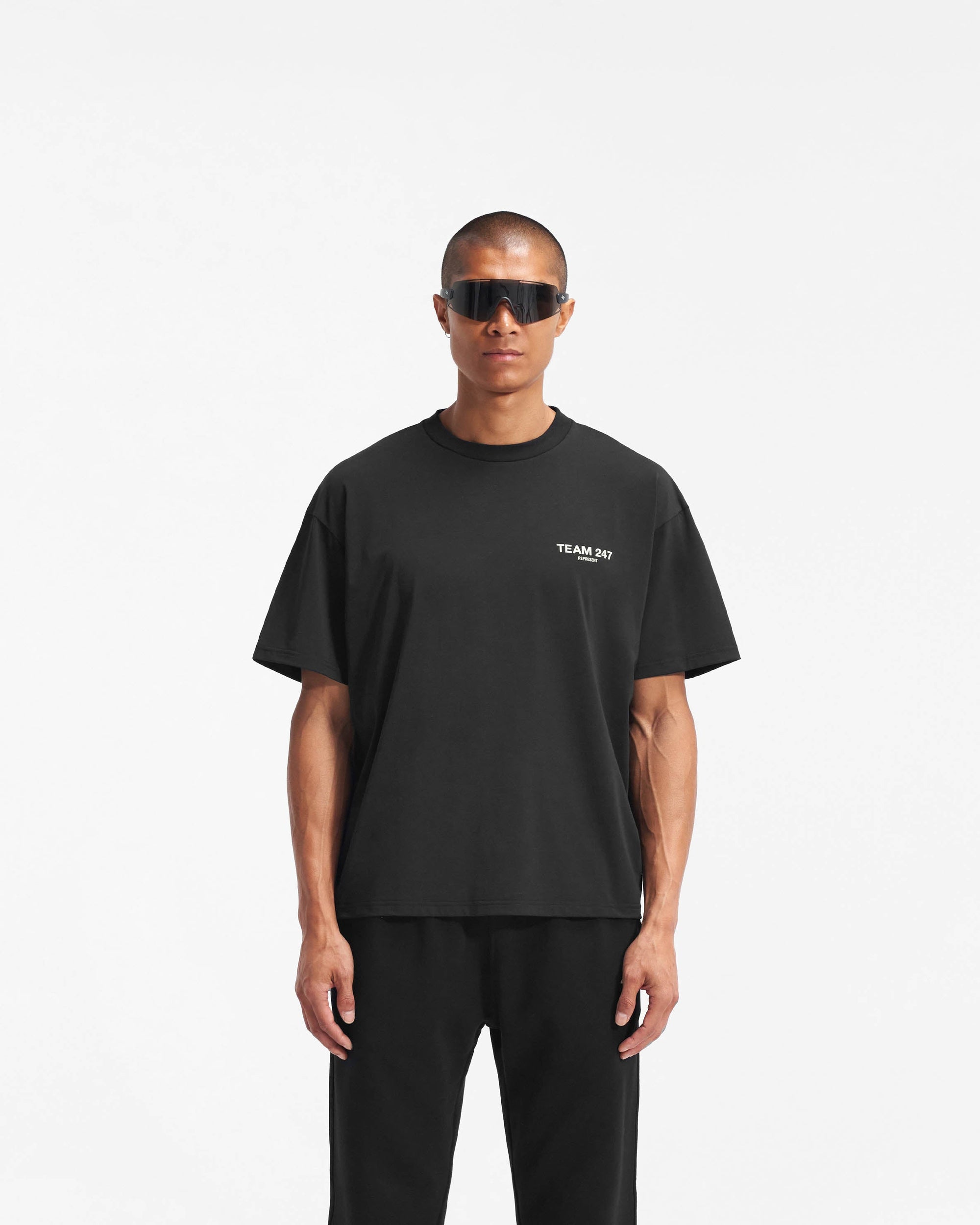 Man wearing an oversized black t-shirt on a plain white background | Team 247 Oversized T-Shirt in Black | Gym top with 4-way stretch and Team 247 branding | 247 T-Shirts | Represent Clo