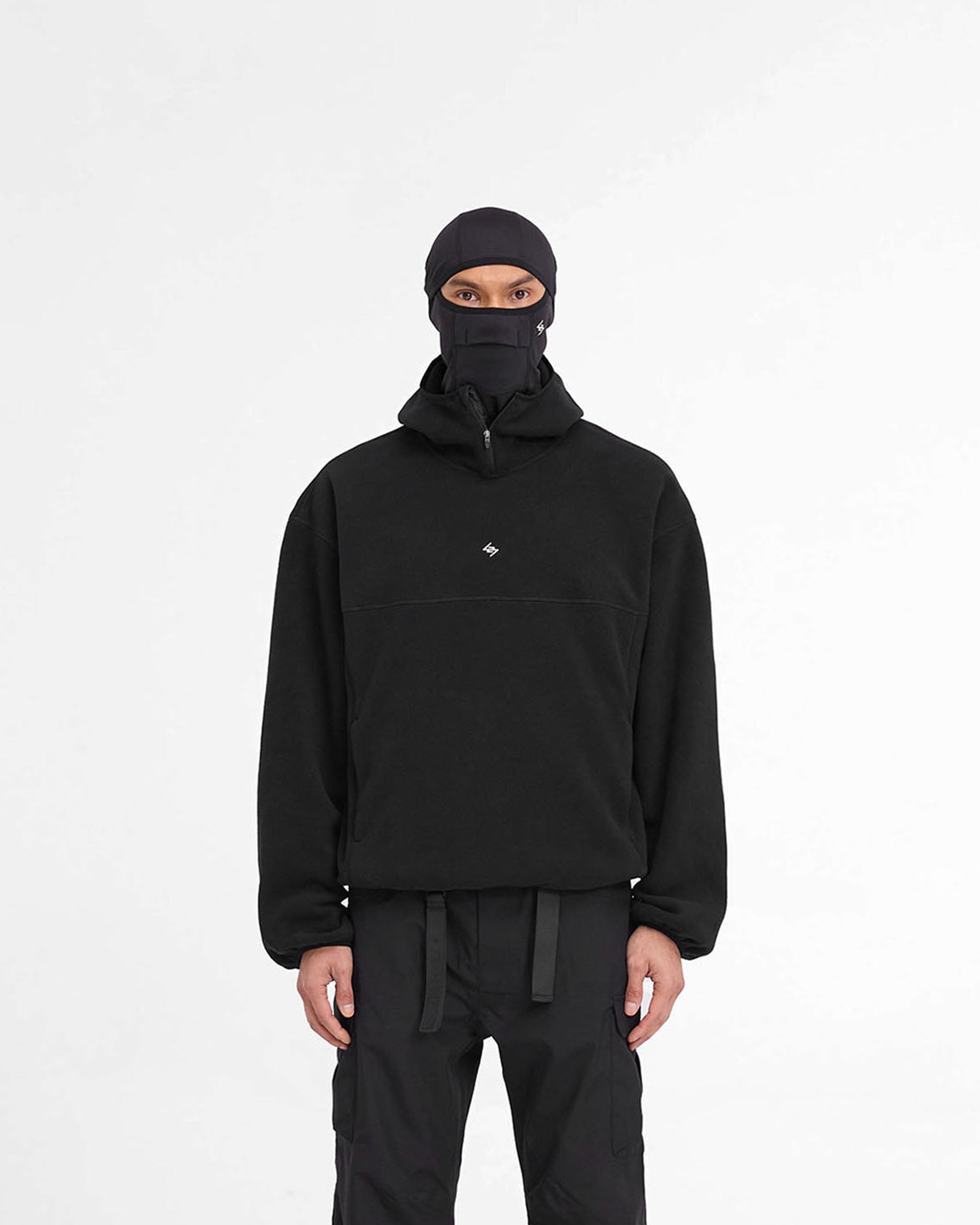 Man wearing a black fleece hoodie on a plain white background | 247 Fleece Hoodie in Black | Oversized fleece hoodie with high chin guard and zip pockets | 247 Hoodies | Represent Clo