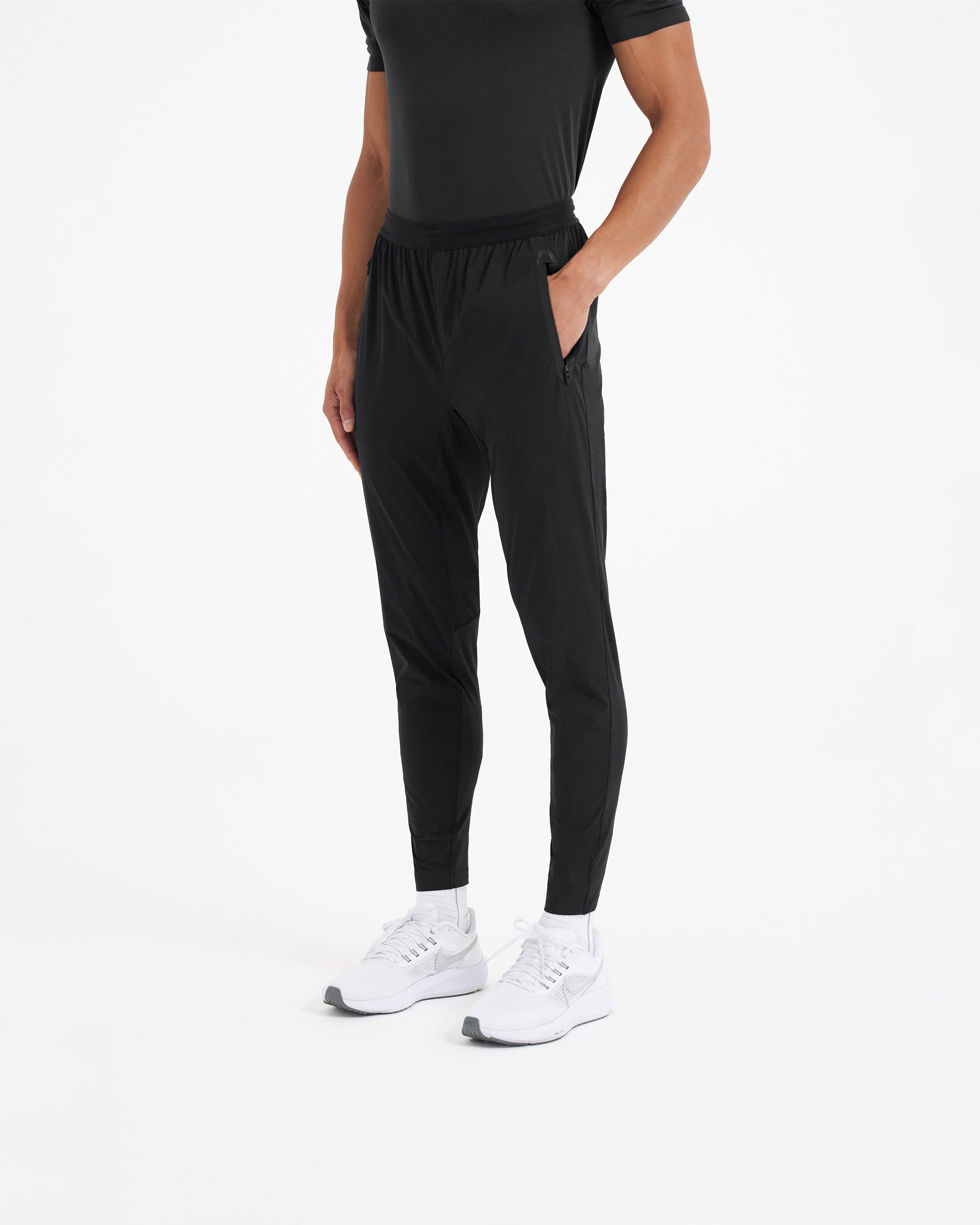 Man wearing black joggers on a plain white background | 247 Active Jogger in Black | Running pants with 4-way stretch and zip pockets | 247 Pants | Represent Clo
