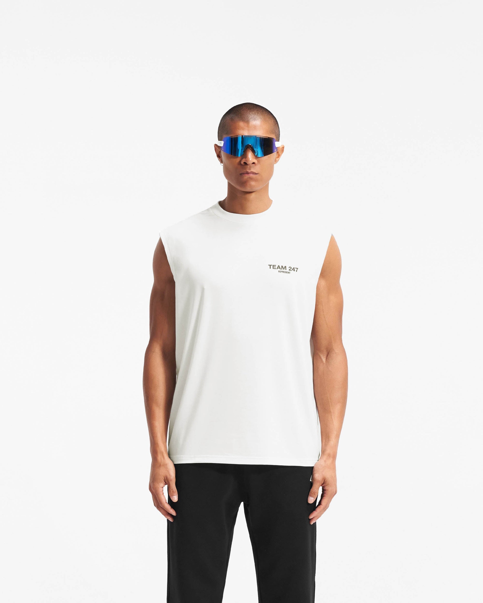 Man wearing an oversized white tank on a plain white background | Team 247 Oversized Tank in Flat White | Lightweight breathable tank top | 247 T-Shirts | Represent Clo