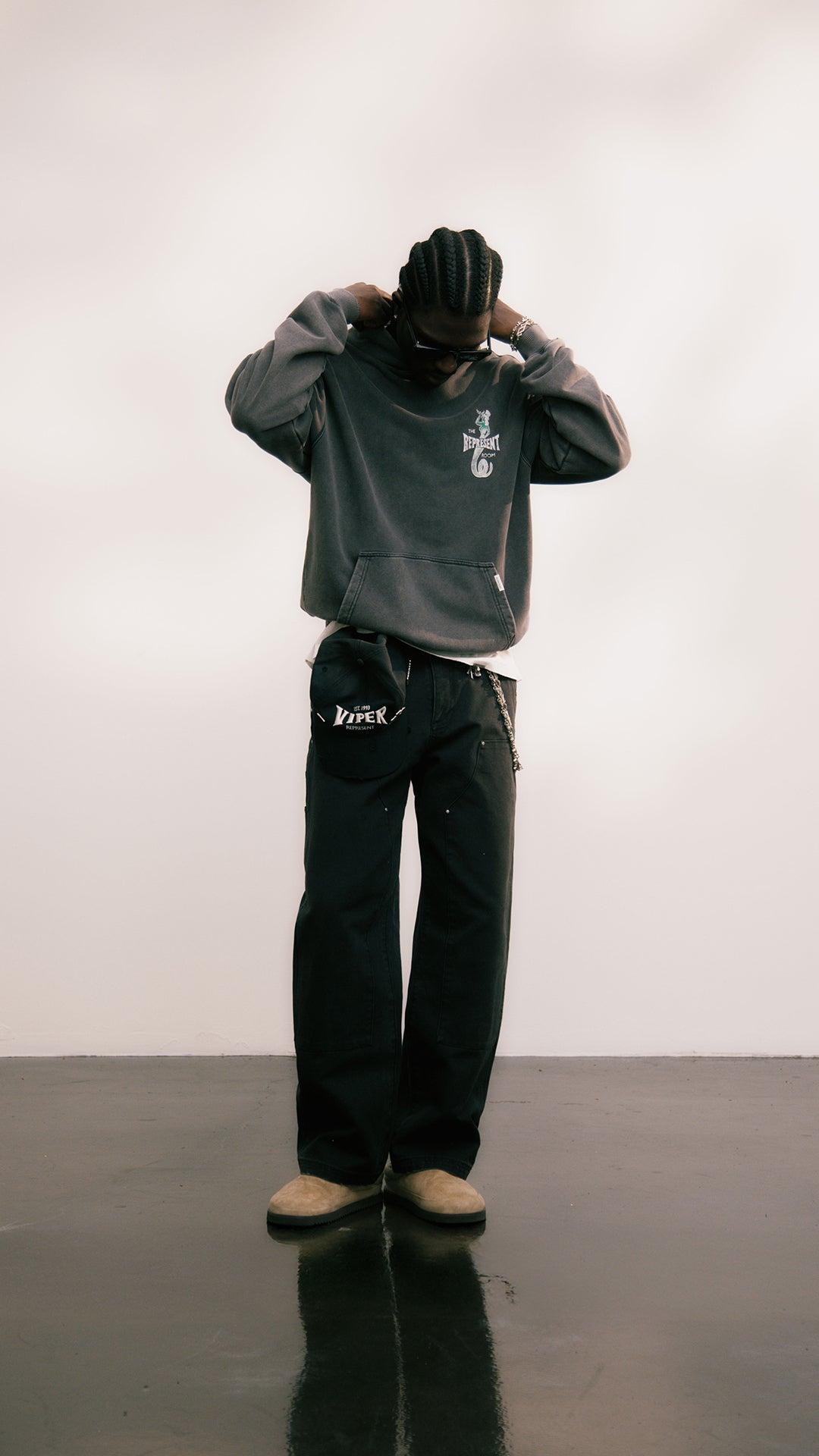 Represent SS26 Drop 2 lookbook: model in grey oversized sweatshirt and dark wide-leg trousers
