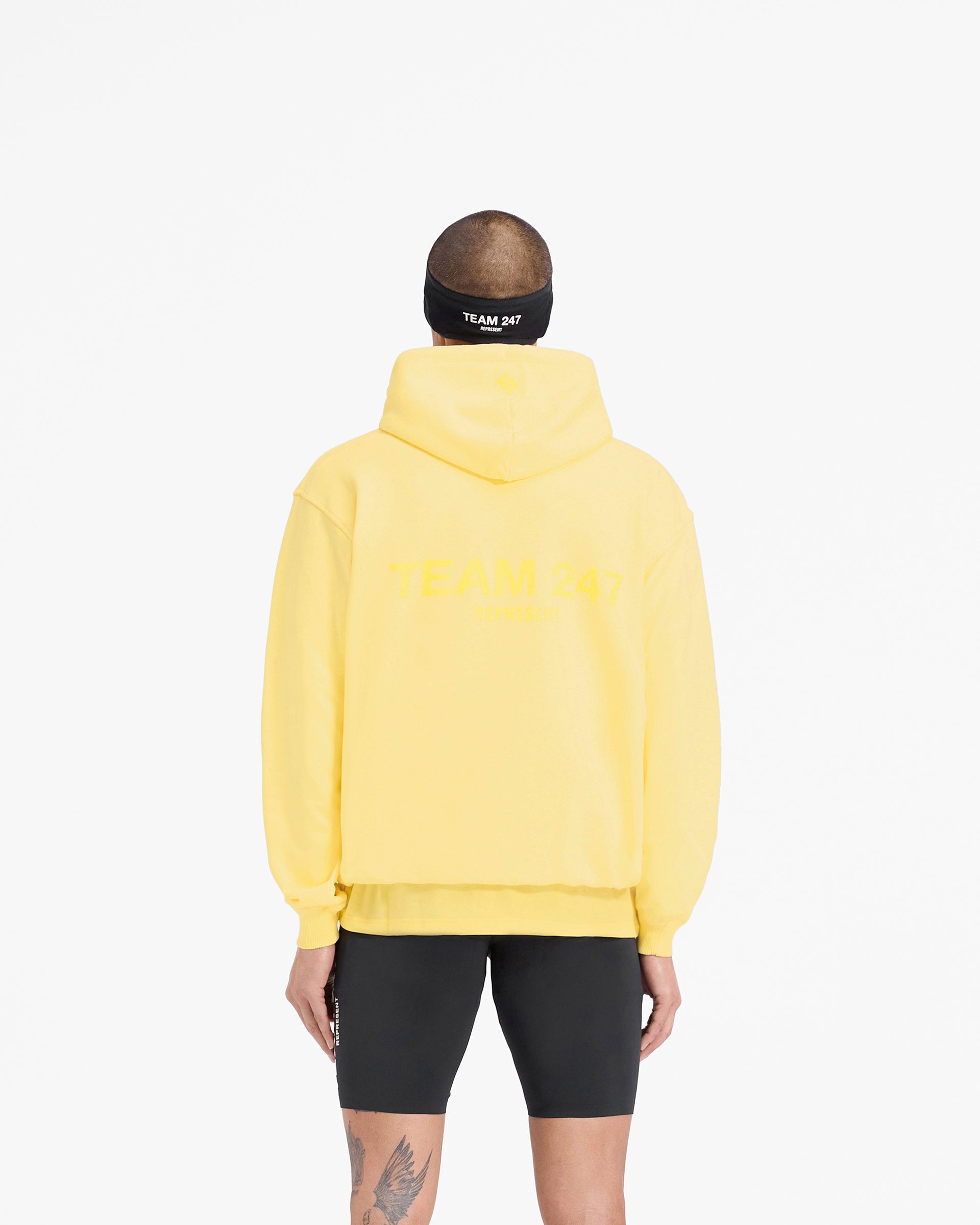 Man wearing an oversized yellow hoodie on a plain white background | Team 247 Oversized Hoodie in Lemon | Hoodie with ribbed cuffs and hem | 247 Hoodies | Represent Clo