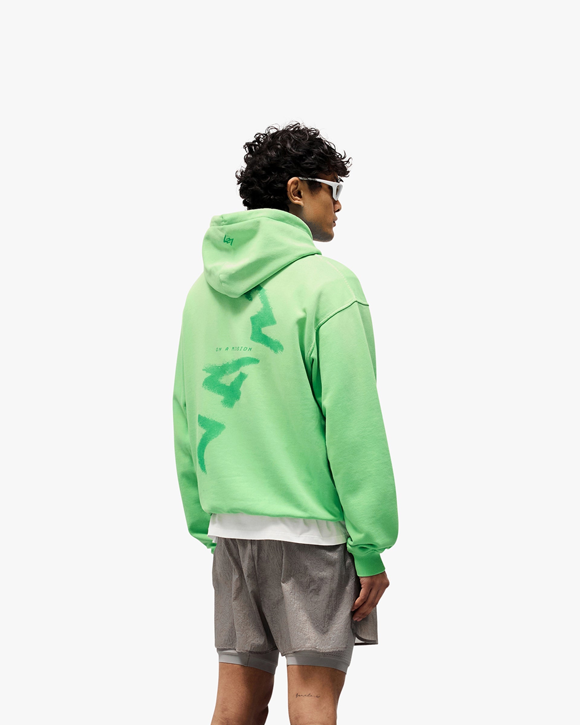 Man wearing an oversized green hoodie on a plain white background | 247 Motion Oversized Hoodie in Speed Green | Hoodie with ribbed hem and cuffs | 247 Hoodies | Represent Clo