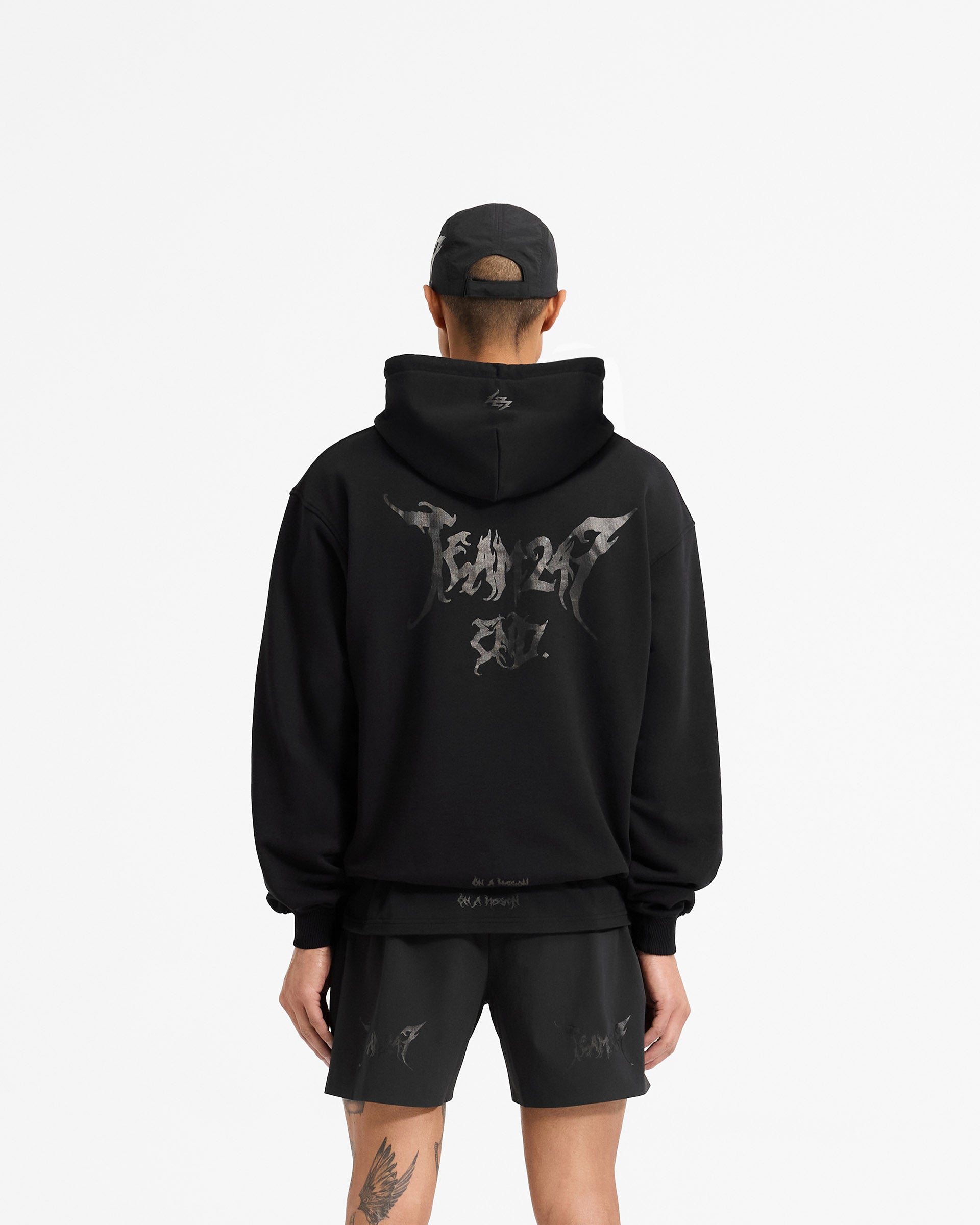 Man wearing a black hoodie on a plain white background | Team 247 X END Oversized Hoodie in Jet Black | Oversized fit hoodie with co-branded graphics | 247 Hoodies | Represent Clo